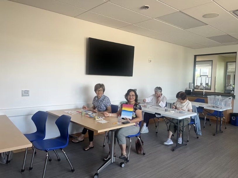 Participants painting at a table in a bright room
