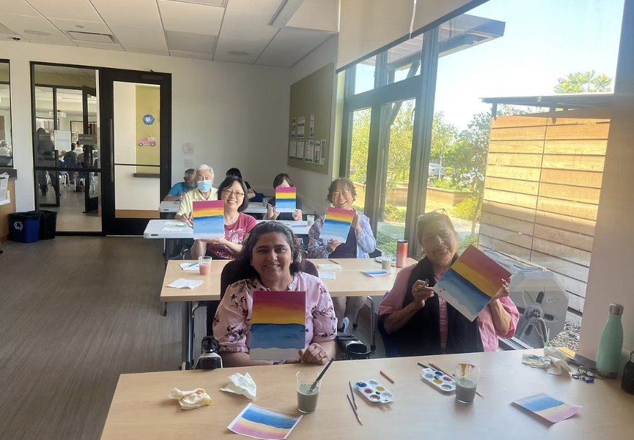 A long room with participants showing their sunset paintings