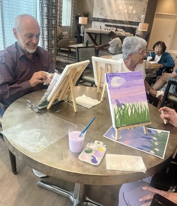 Residents painting at easels around a round table