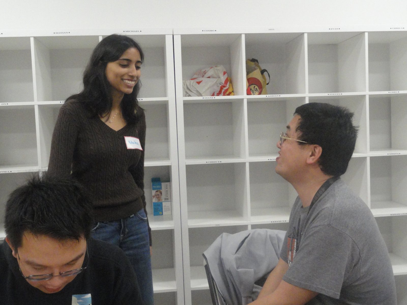 A CARES officer chatting with a participant in front of white shelves
