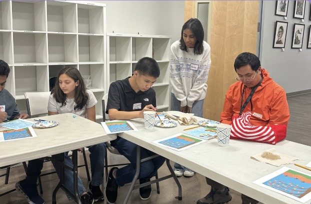 Participants and CARES officers painting at a table