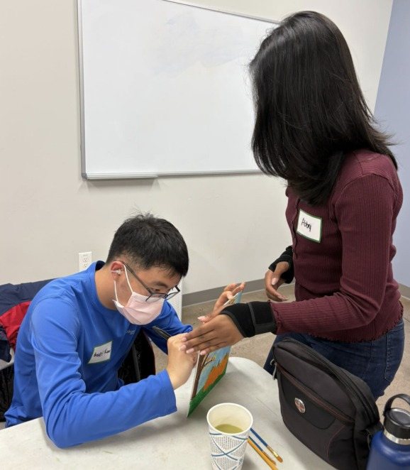 A participant working on his painting with help from a CARES officer