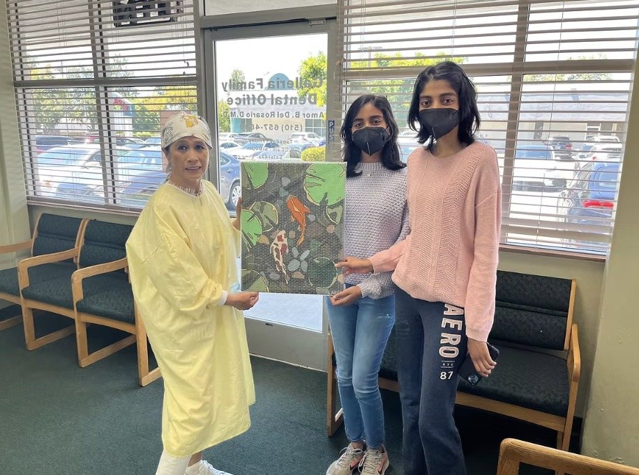 CARES officers presenting the koi pond painting "Tranquility" at the dental office