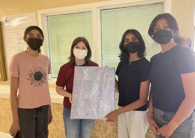 CARES officers holding the wrapped painting at Lake Merritt Healthcare Center