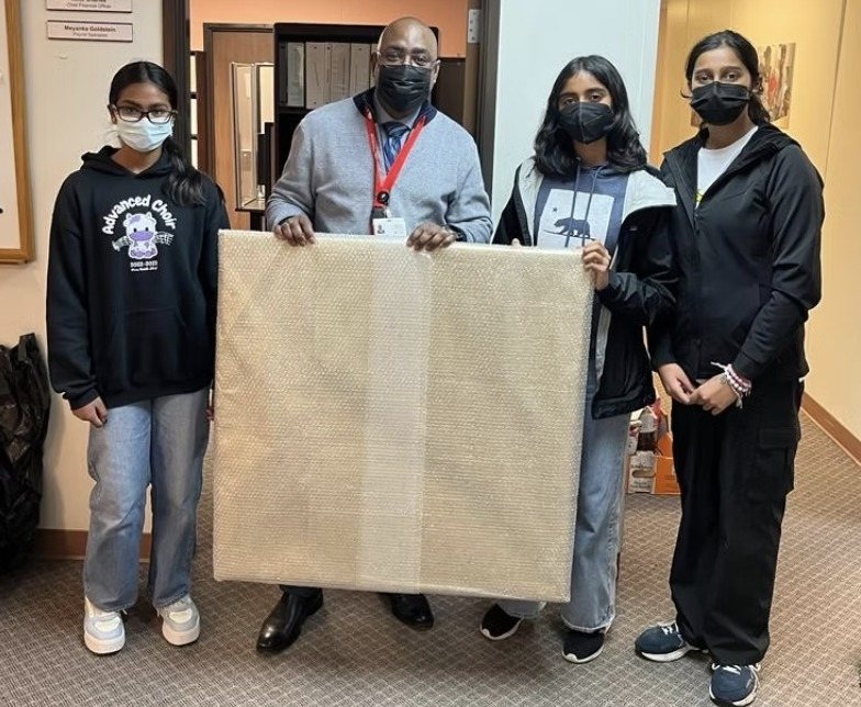 CARES officers delivering the wrapped painting to Ravenswood staff