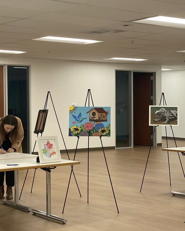 CARES paintings displayed on easels at the event