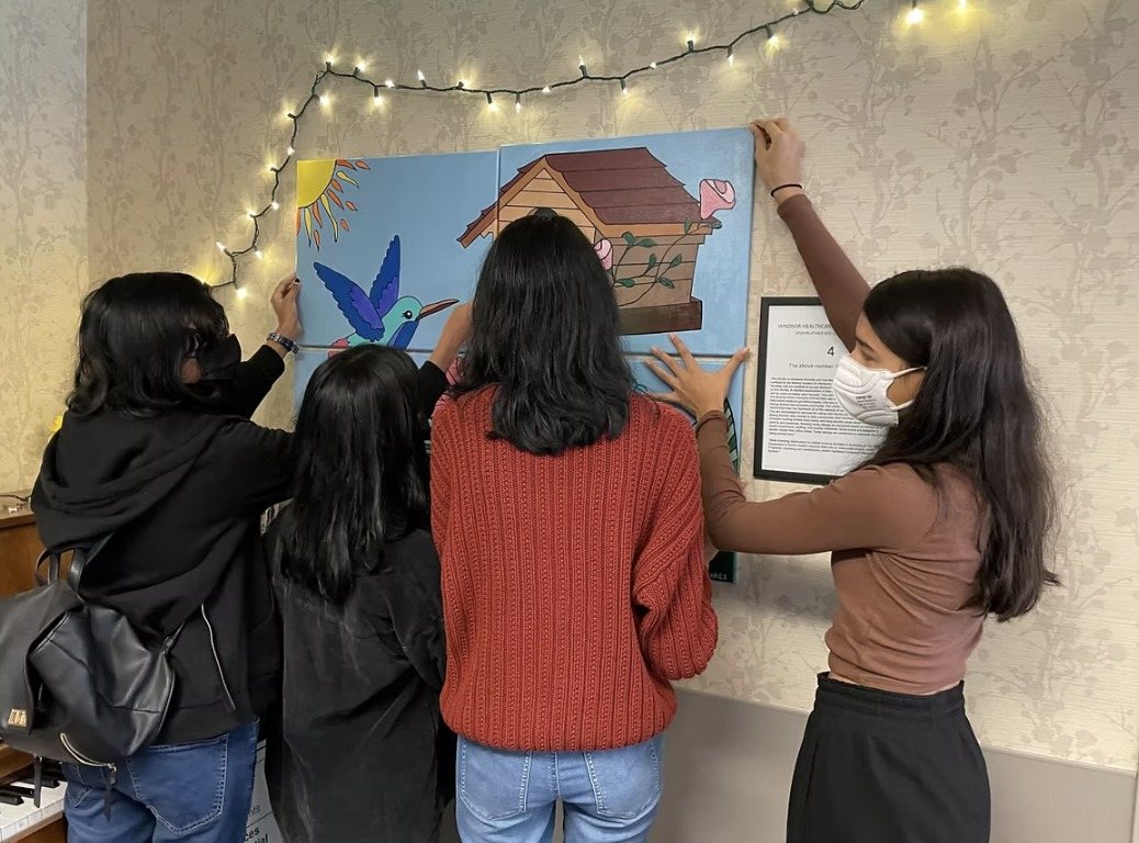 CARES officers hanging the painting on the wall